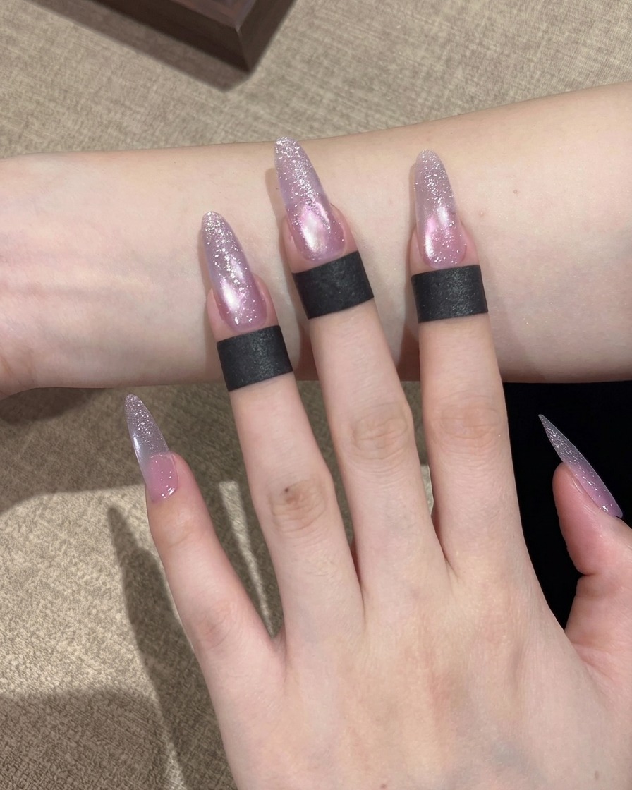 Un pennello che applica uno smalto gel cat eye dai toni viola brillanti sullintera superficie dellunghia.