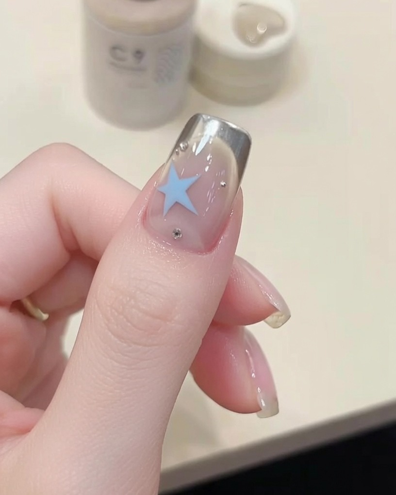 Un pennello che applica un top coat trasparente e lucido su ununghia curata.