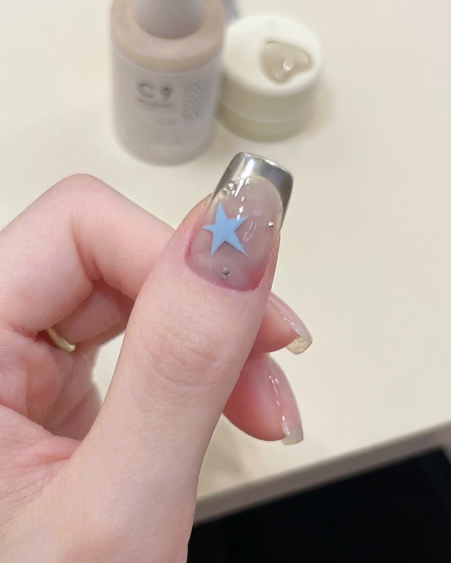 Un pennello che applica uno strato lucido di gel sopra la nail art completata.