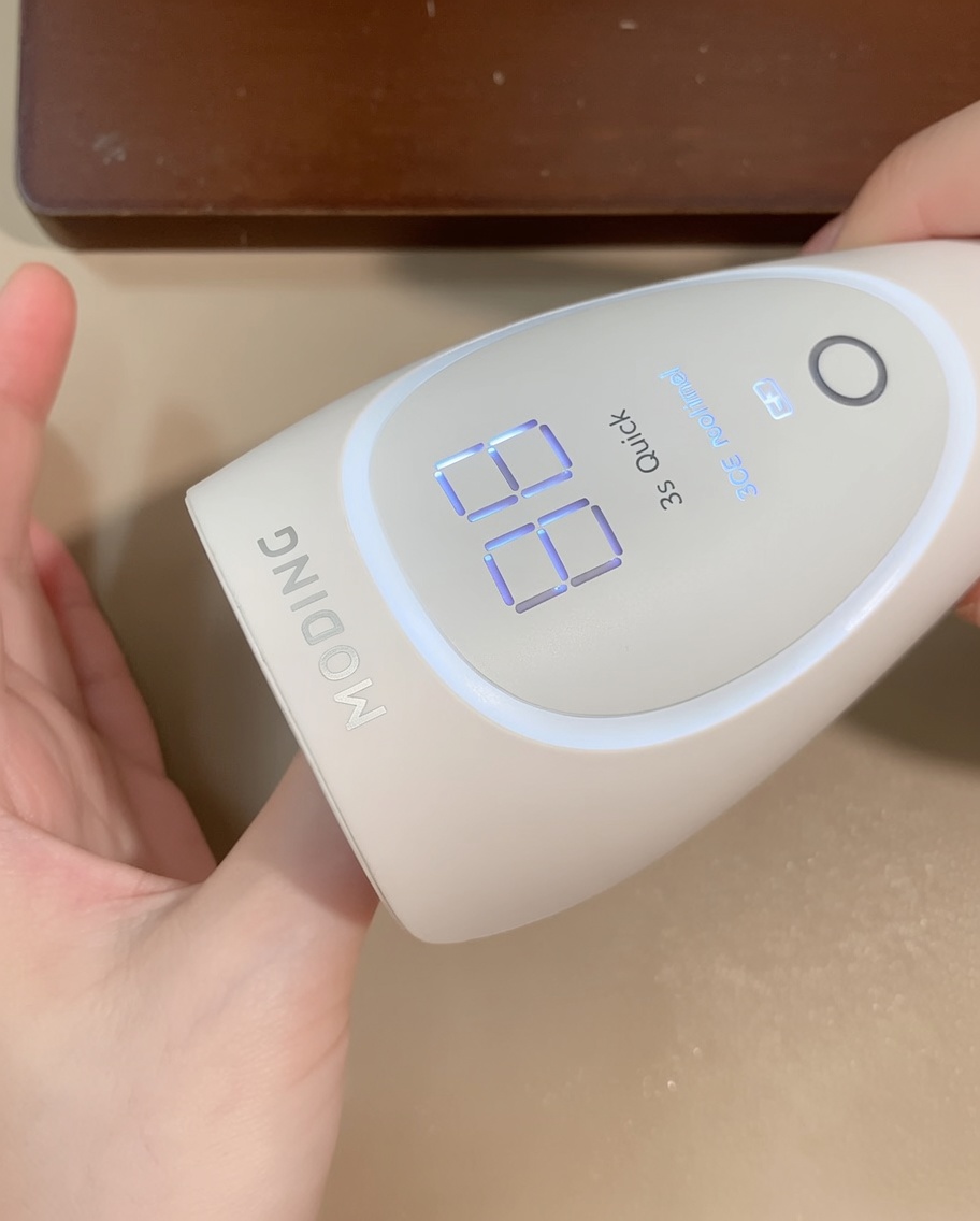 Una mano sotto la lampada LED portatile, con il display digitale visibile.