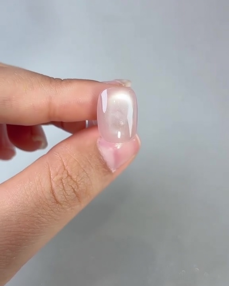 Applicazione di top coat lucido su ununghia cat-eye polimerizzata.