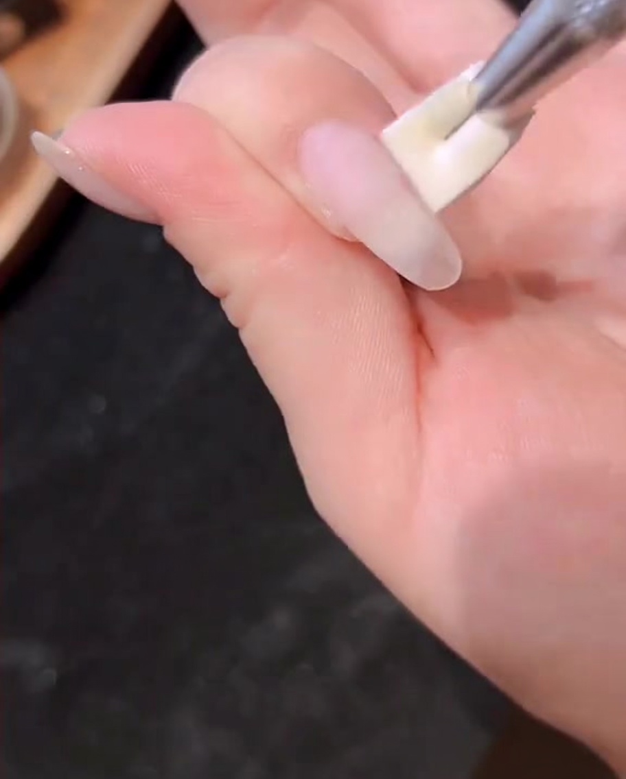 Una mano allinterno di una lampada UV/LED professionale con la luce attivata.