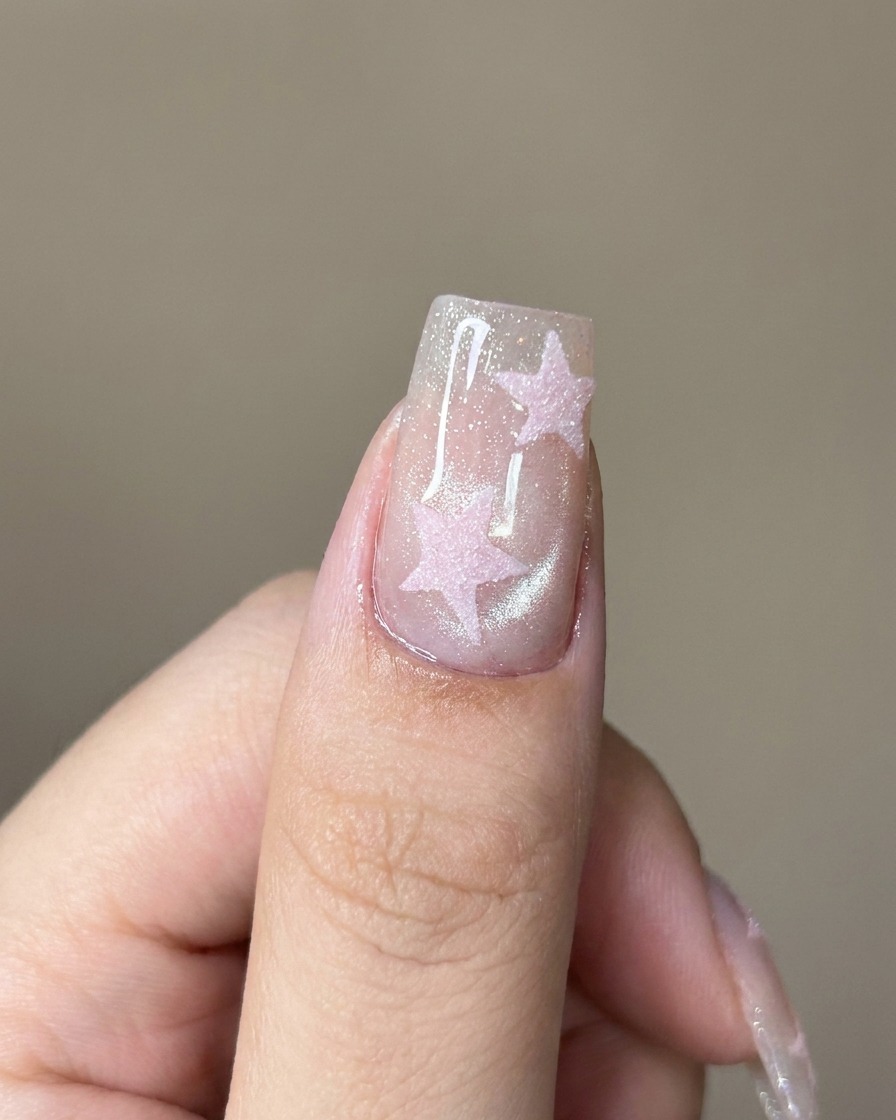 Un pennello che applica un top coat trasparente sopra lunghia cat-eye scintillante.