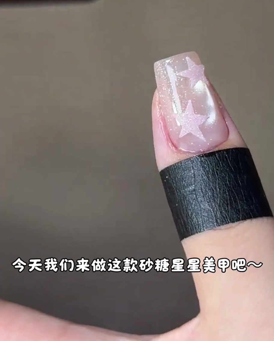 Ununghia con un design a stella rosa che viene polimerizzata sotto una lampada UV.
