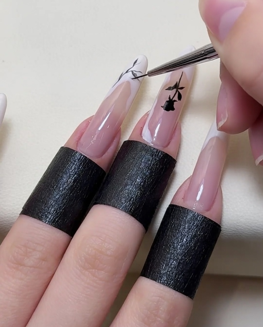 Un primo piano di un pennello che aggiunge ulteriori dettagli intricati a forma di ramo alla nail art.