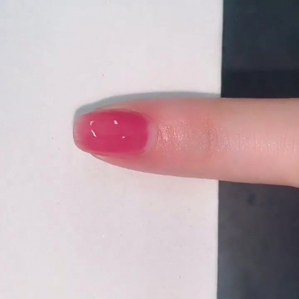 Ununghia rivestita da uno strato lucido e traslucido di smalto jelly rosa.