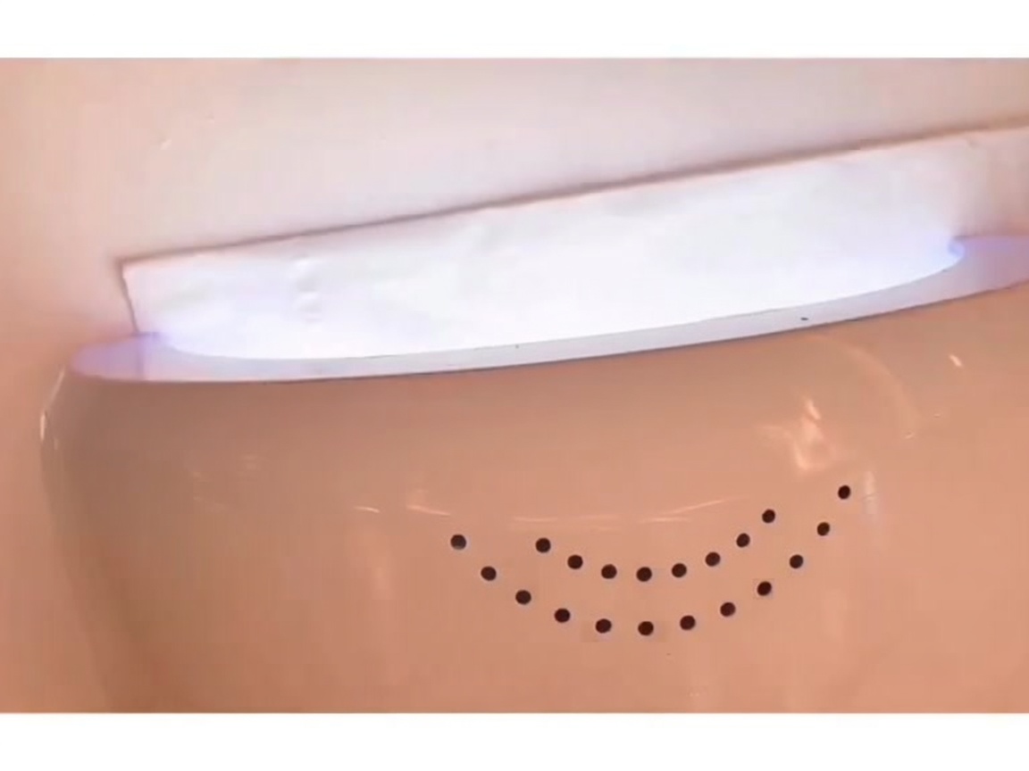 Una mano inserita allinterno di una lampada LED per unghie con la luce accesa durante la polimerizzazione.
