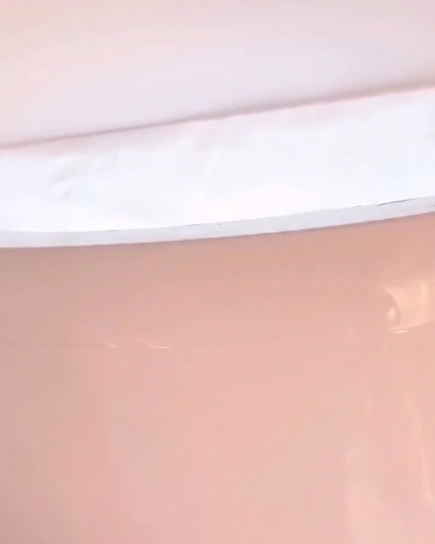 Primo piano di una mano che riposa allinterno di una lampada LED con luce rosata.