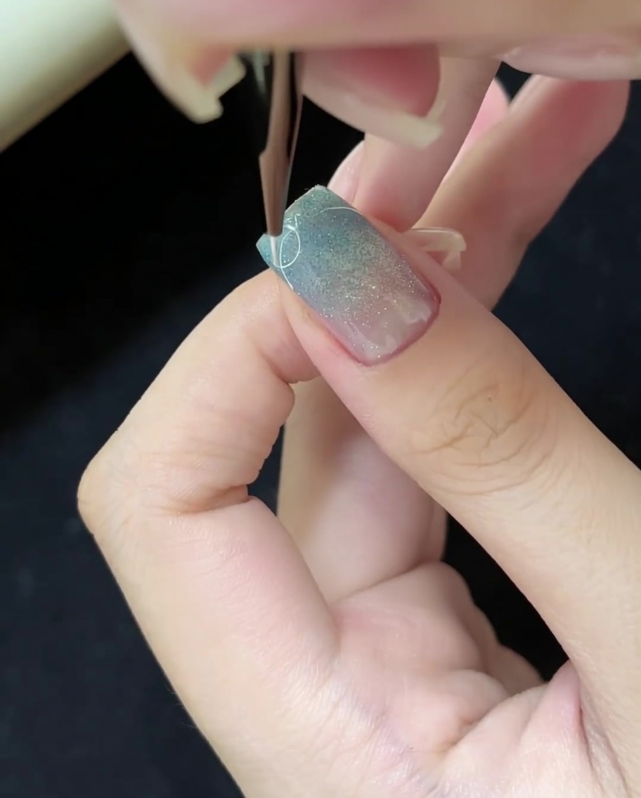 Uso di un pennello liner sottile per disegnare linee bianche fini sulla superficie dellunghia.