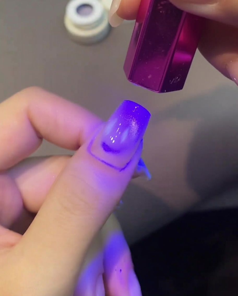 Lunghia con effetto cat eye viola sotto la lampada UV.