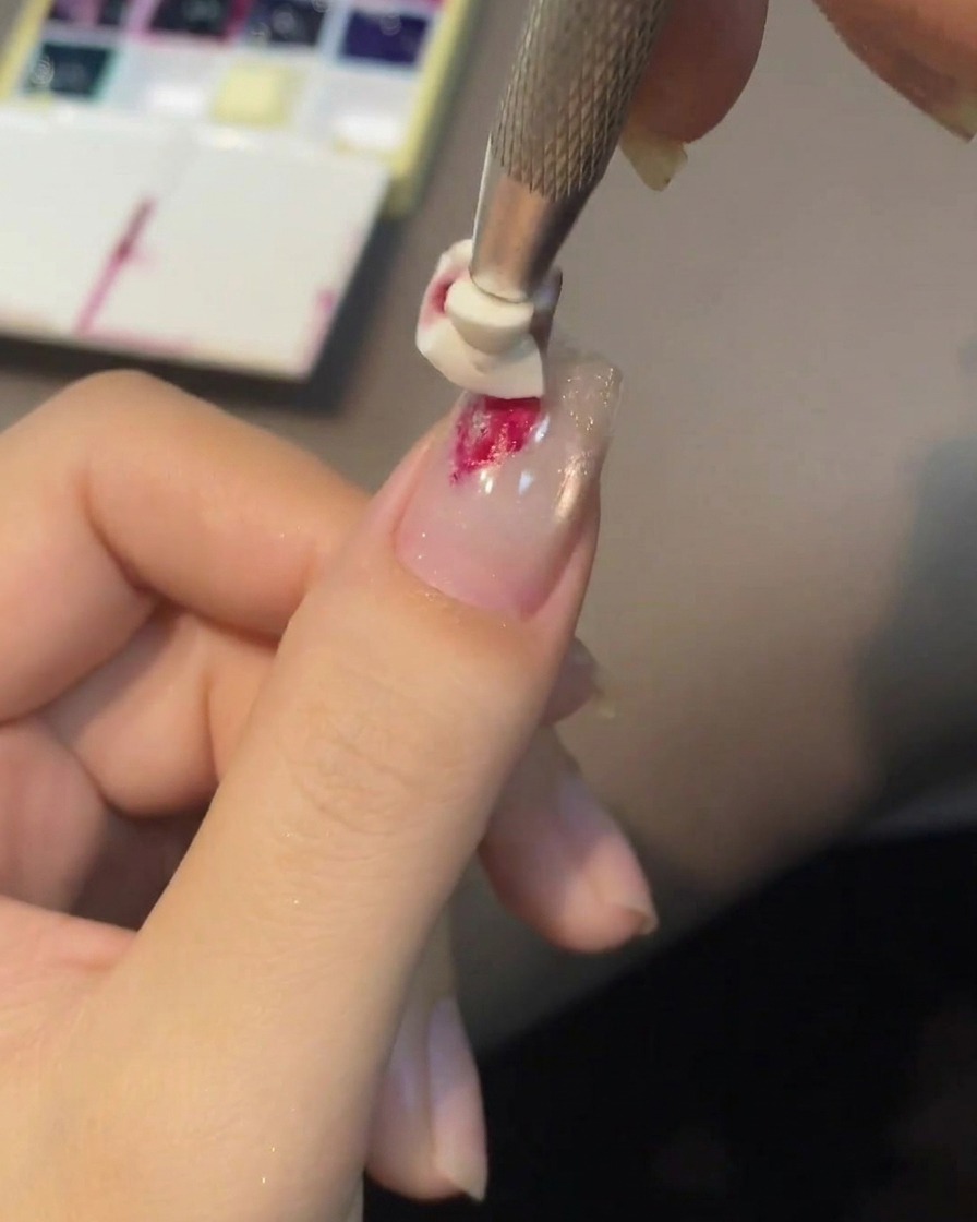 Uno stampino in silicone che preme sulla goccia di gel per dare forma alla rosa.