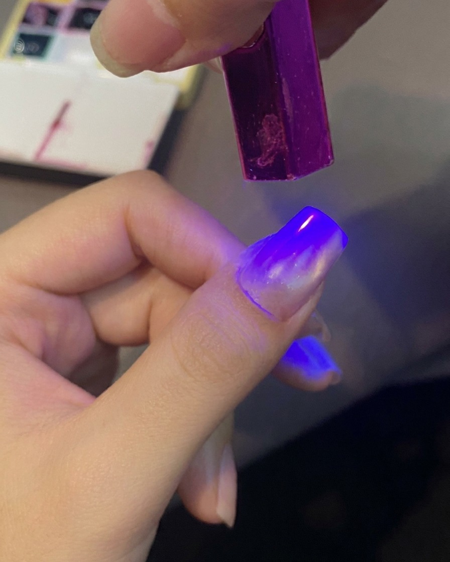 Lunghia che polimerizza sotto una piccola lampada UV.