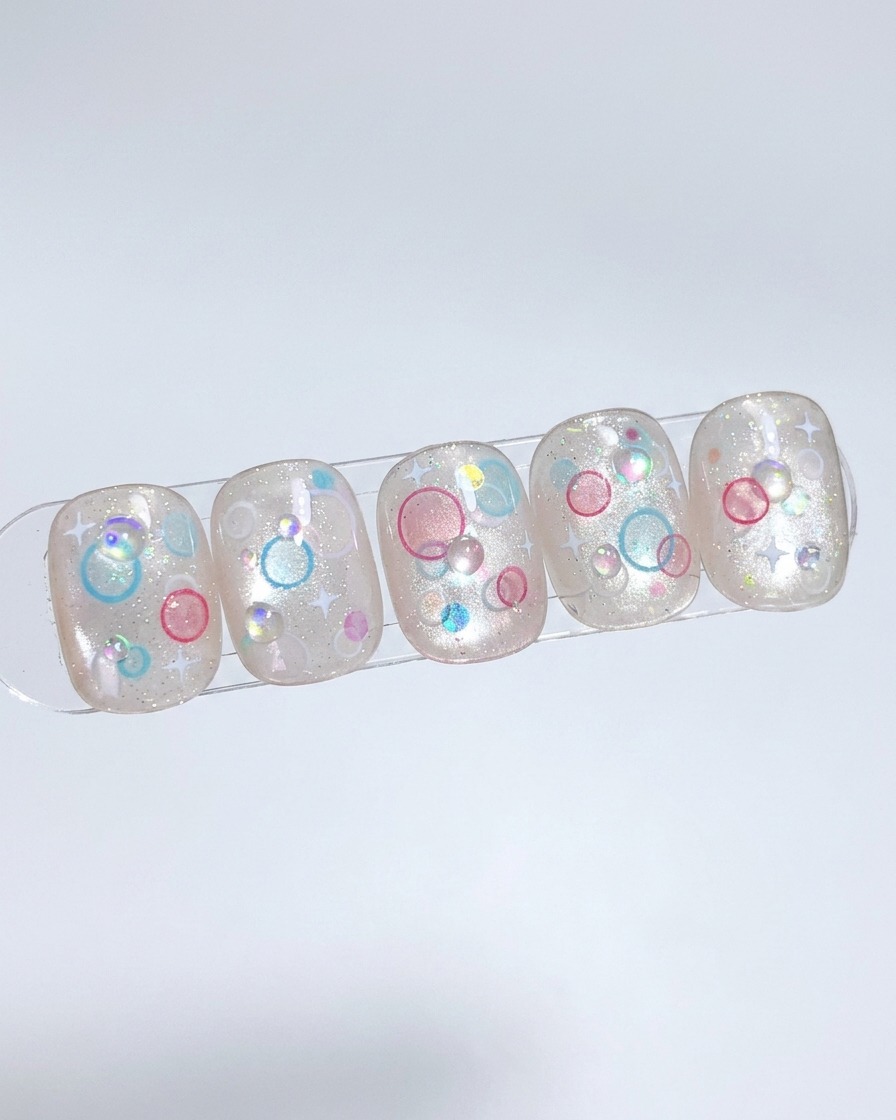 Un pennello applica uno strato di gel nude su una tip, picchiettandolo per una distribuzione uniforme.