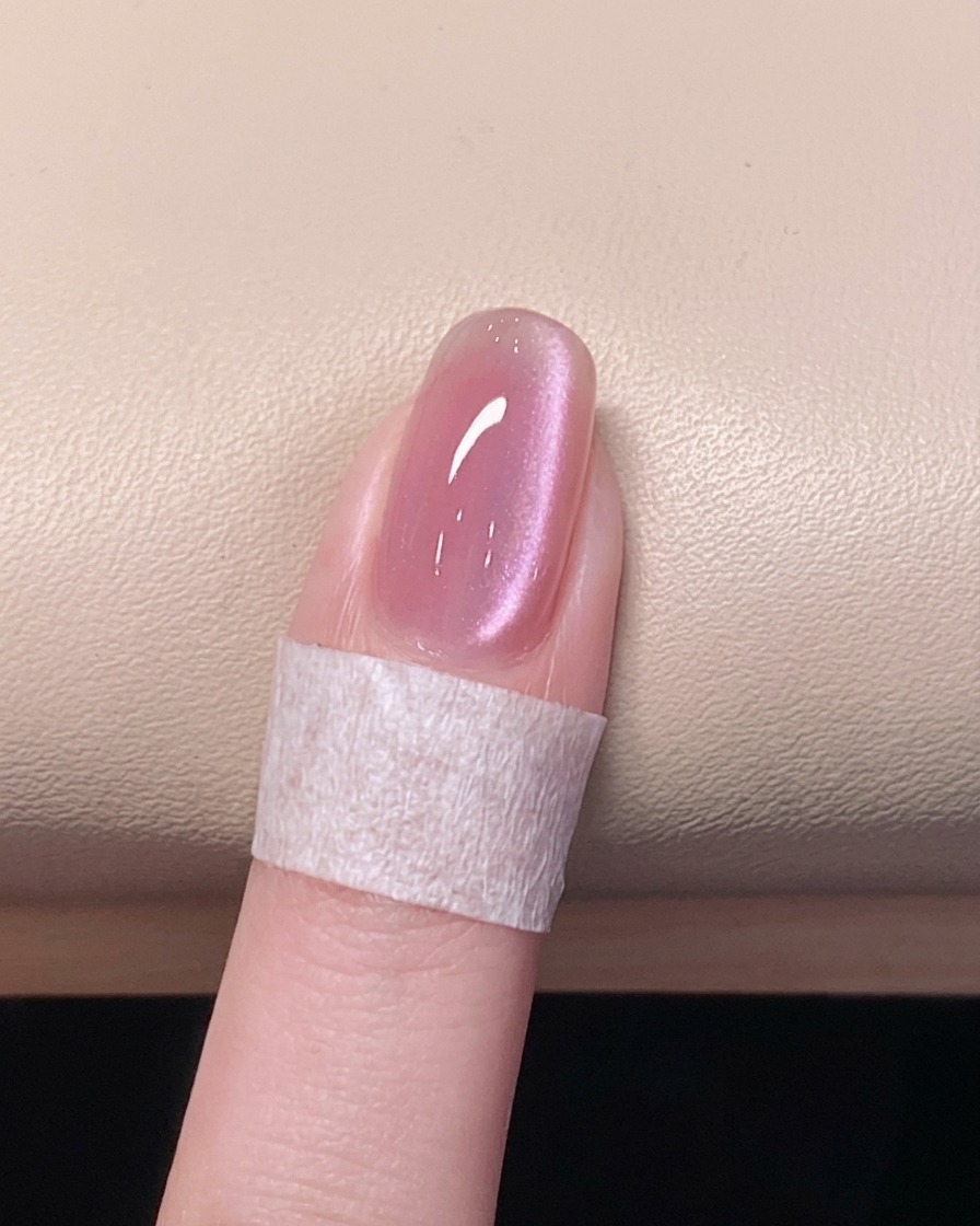 Una mano appoggiata allinterno di una lampada UV/LED accesa per polimerizzare il top coat finale.