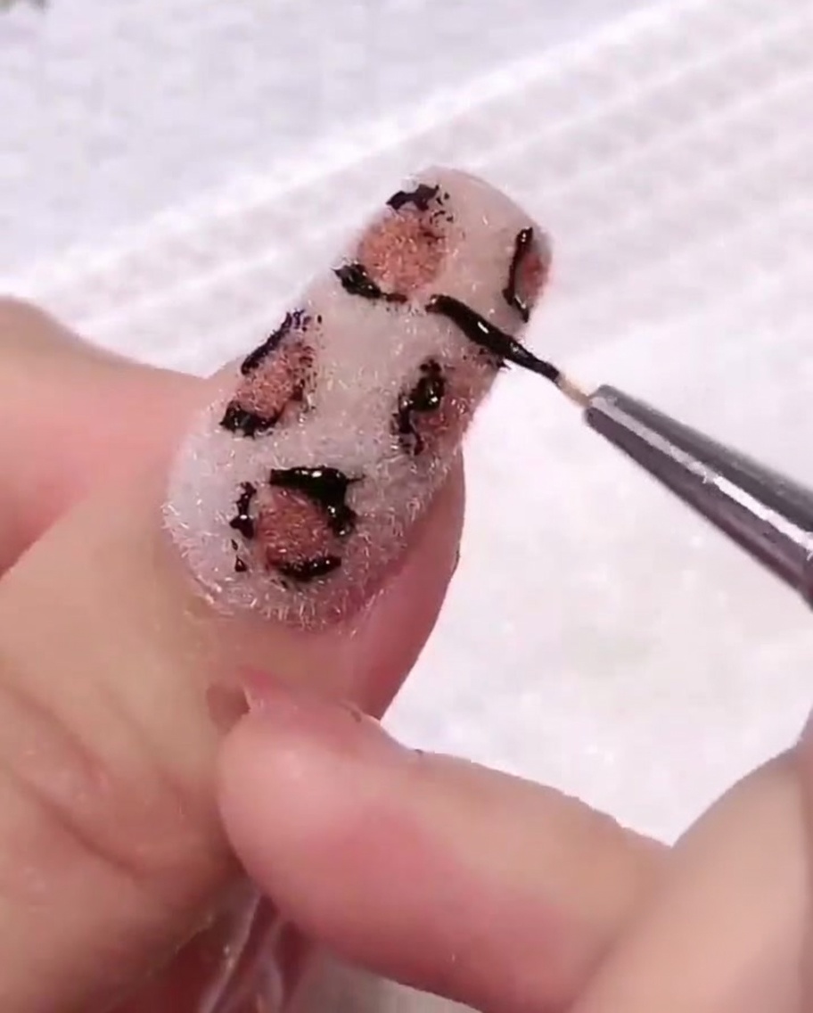 Un dischetto di cotone utilizzato per pulire delicatamente la superficie dellunghia, eliminando residui di gel nero vicino al design.
