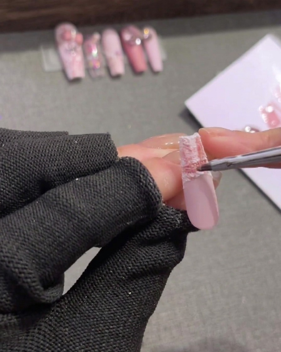Un pennello applica un gel rosa medio sul bordo superiore della punta per ammorbidire il passaggio.