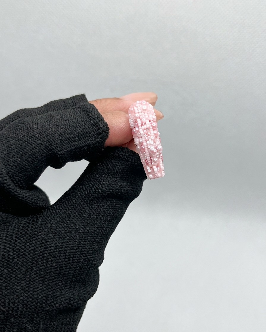 Un pennello applica gel base trasparente su una tip non decorata.