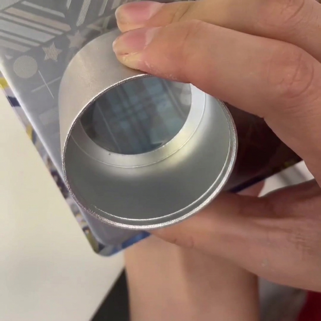 Un raschietto di plastica trascinato su un disco metallico per stamping con smalto blu nel disegno inciso.