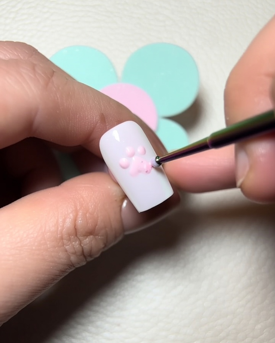 Pennello che applica gel scultoreo trasparente sui cuscinetti rosa.