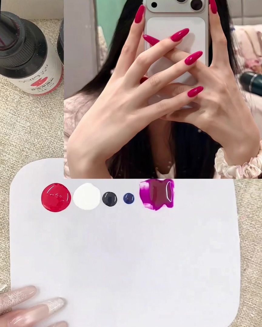 Un primo piano di una spatola di metallo che posiziona noci di gel rosso vibrante e bianco coprente su una tavolozza di miscelazione bianca e pulita.