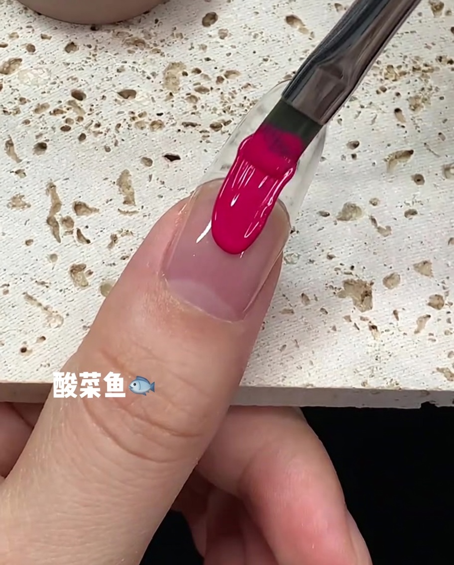 Una pennellata di smalto gel rosa brillante che corre lungo il centro della lamina ungueale.