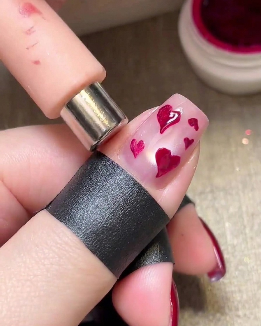 Un magnete tenuto sopra i cuori magenta umidi per creare un effetto metallico brillante.