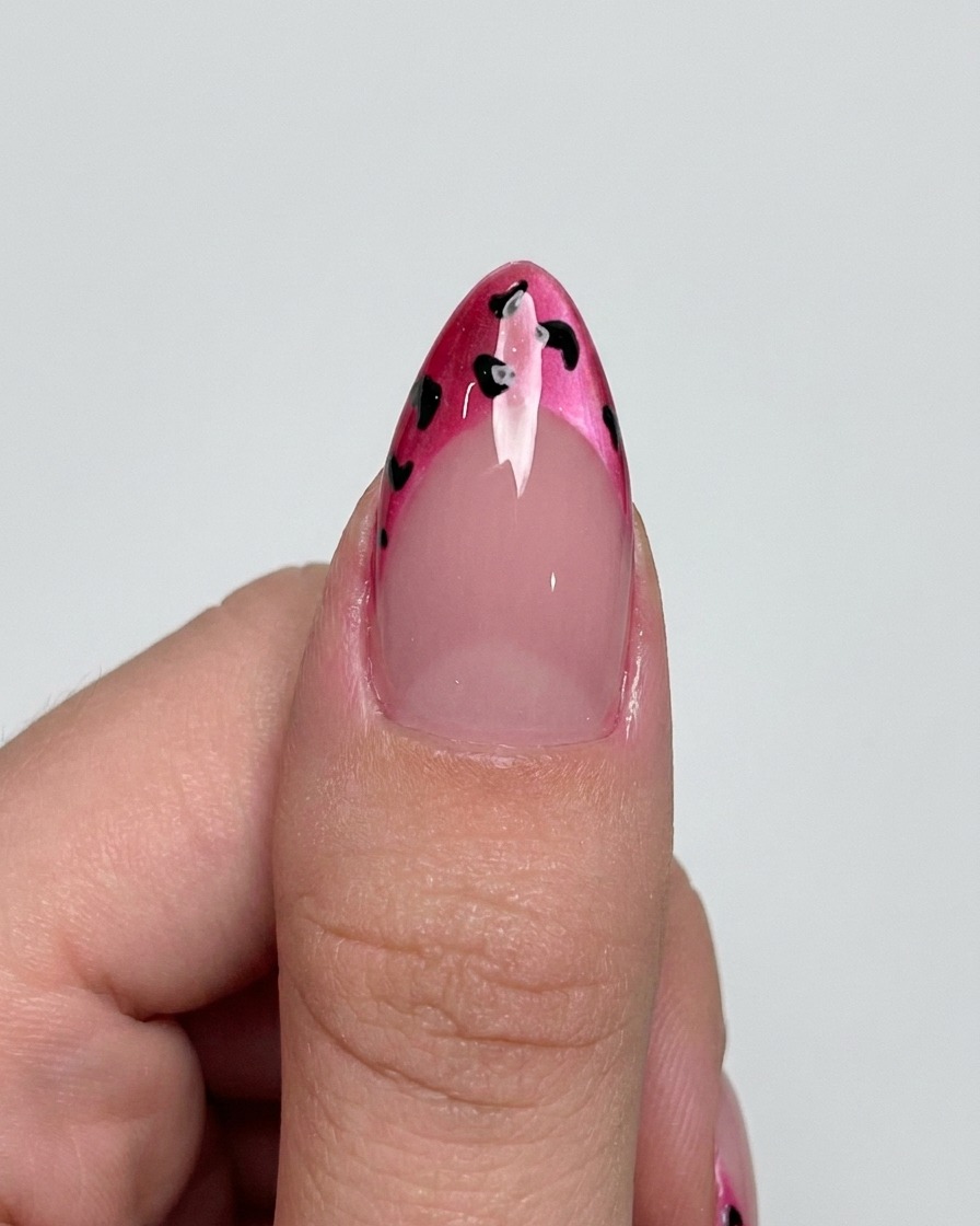 Un pennello liner che aggiunge delicati contorni neri attorno ai punti su una French magenta.