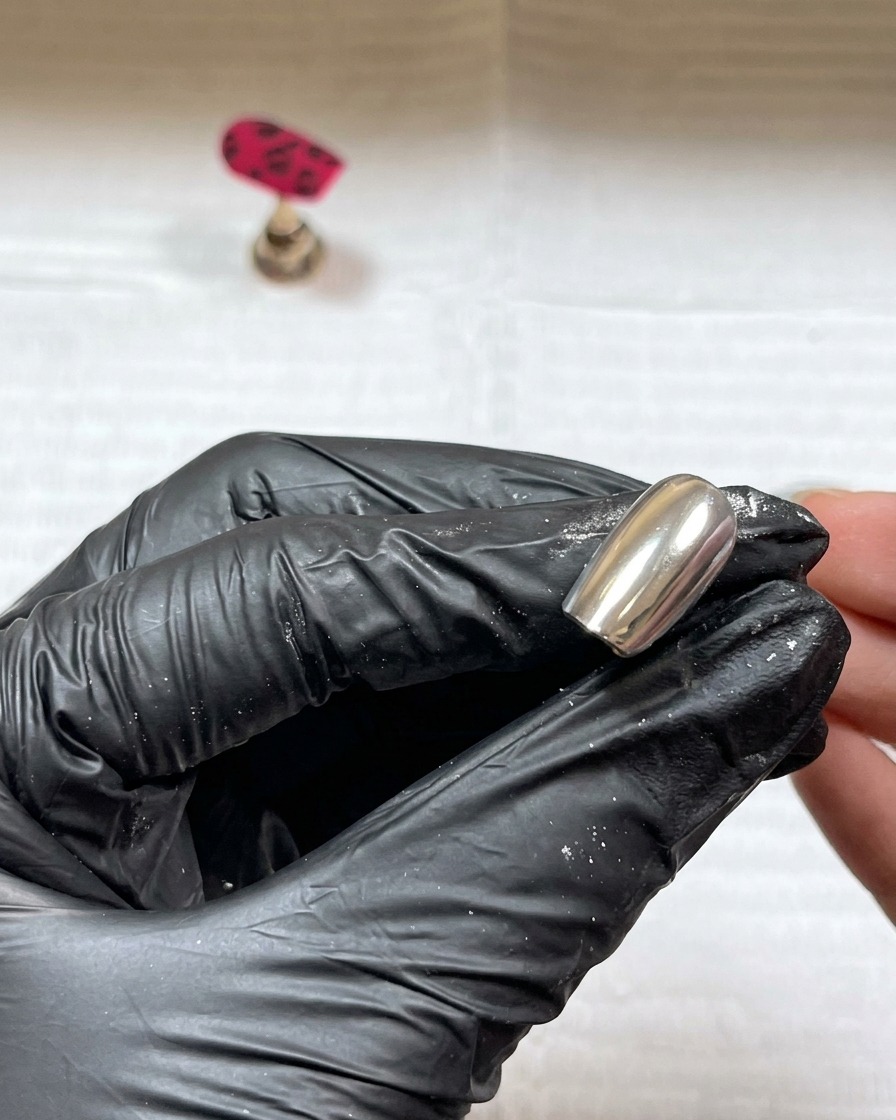 Polvere acrilica trasparente cosparsa sui dettagli in gel nero umido sullunghia.