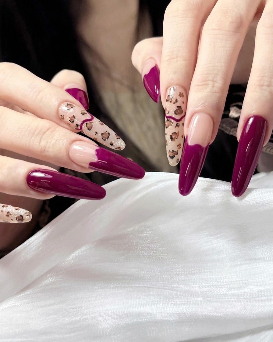 Un pennello che applica un top coat trasparente e ultra lucido sulla manicure finita con stampa leopardata e magenta.