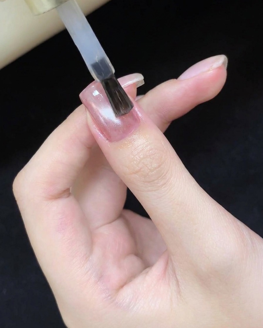 Un pennello che applica un top coat trasparente e lucido sopra il design cat eye polimerizzato.