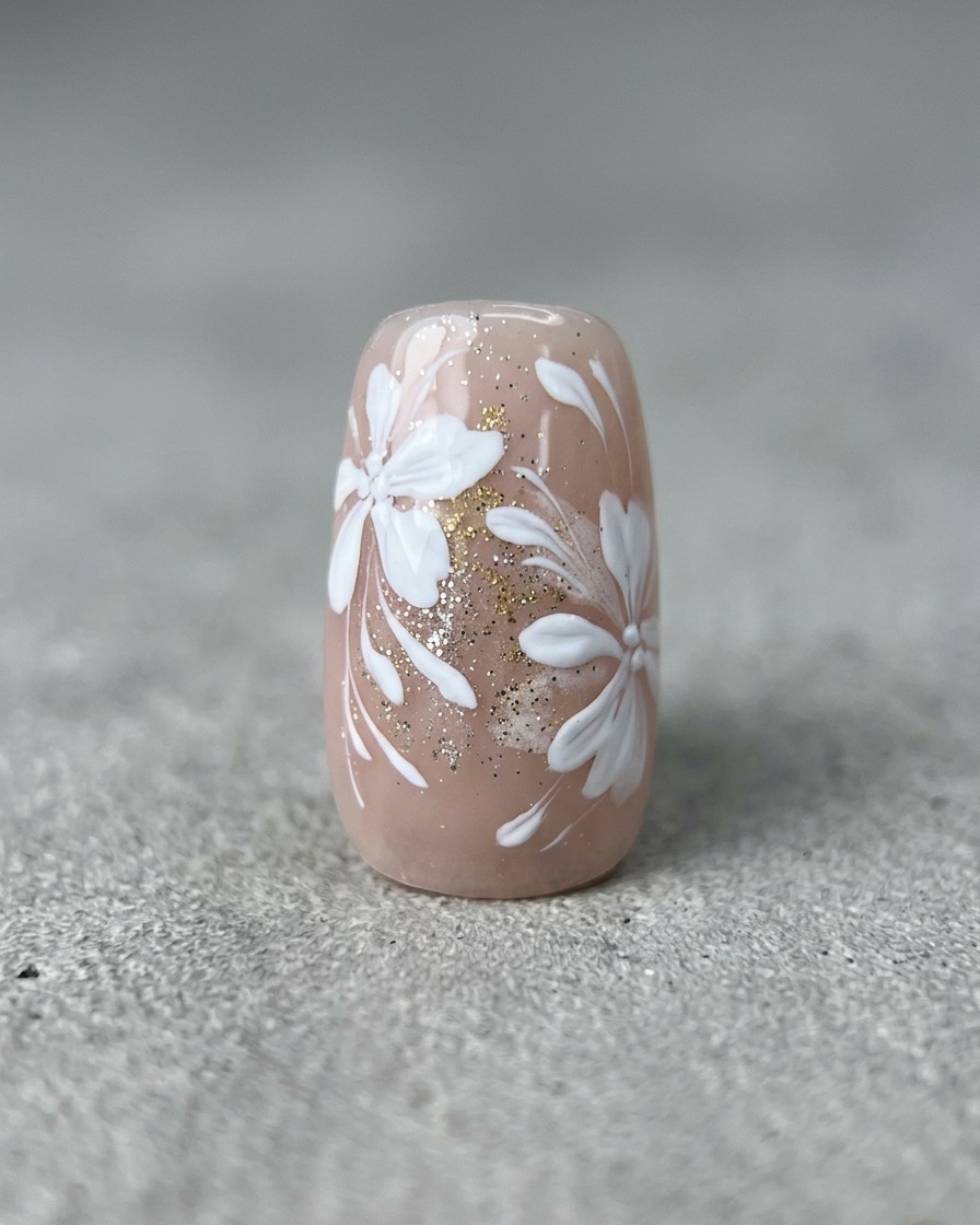 Un pennello liner sottile disegna linee bianche curve su ununghia con art floreale e oro.