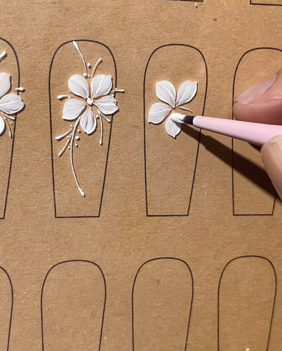 Un pennello piatto rifinisce il quinto e ultimo petalo di gel bianco per completare la forma del fiore.