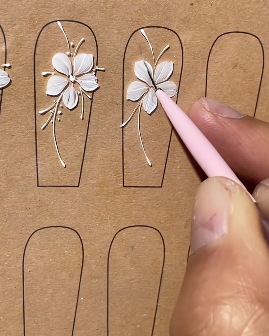 Un pennello aggiunge minuscole linee bianche corte come dettagli decorativi lungo gli steli curvi disegnati in precedenza.