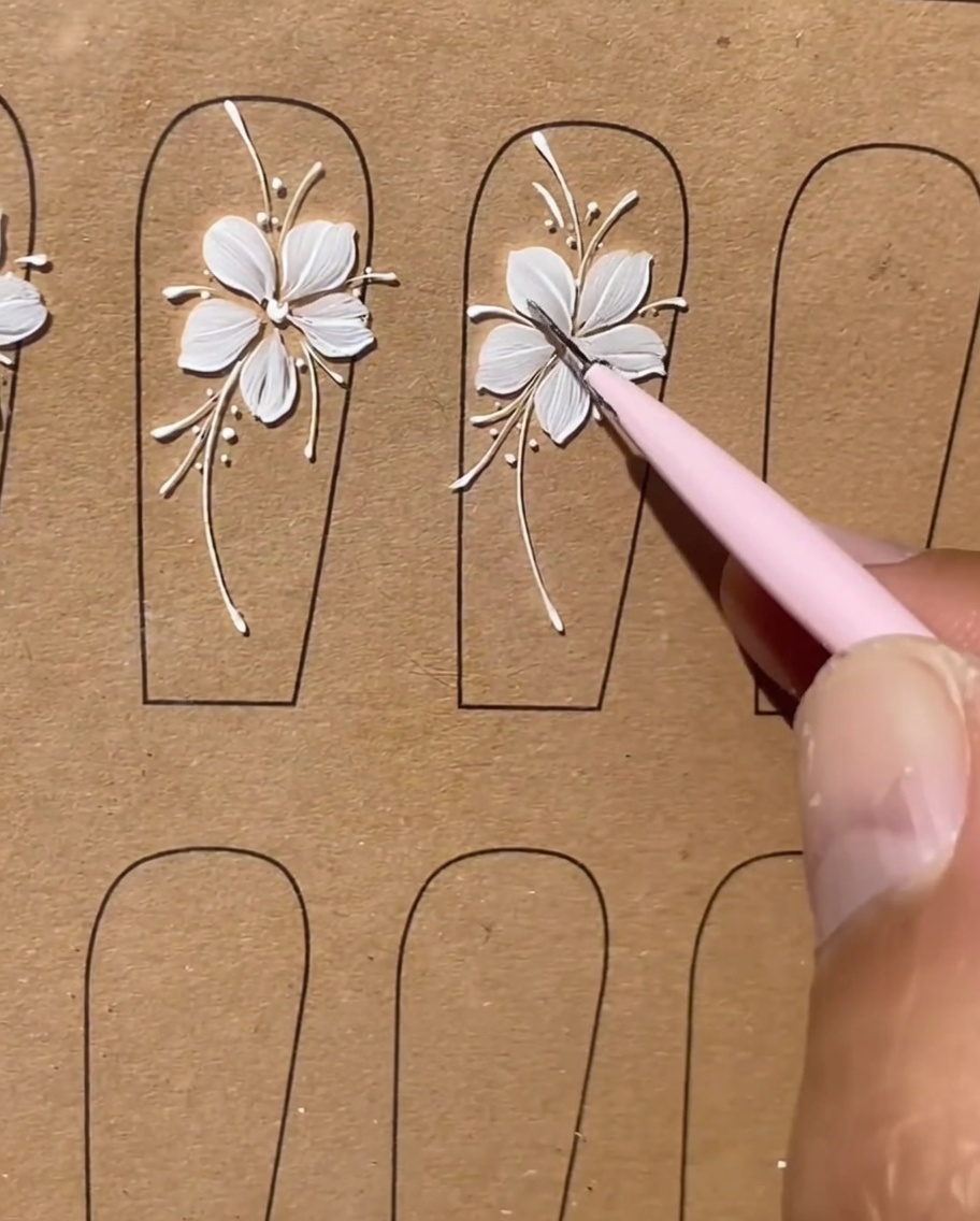 Primo piano finale di una nail art floreale bianca completata con tutte le linee che appaiono pulite e rifinite.