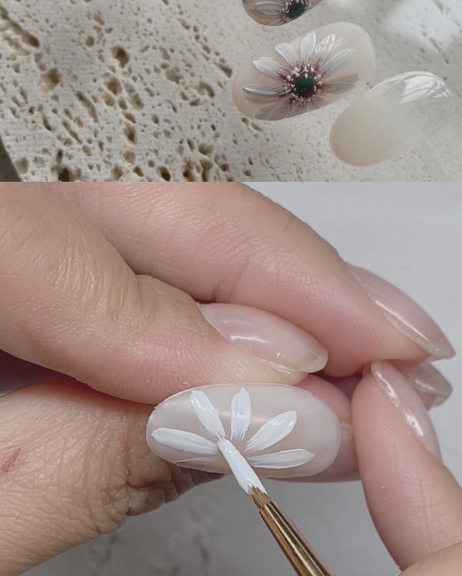 Un pennello che applica un top coat lucido finale su un design di unghie a margherita completato.