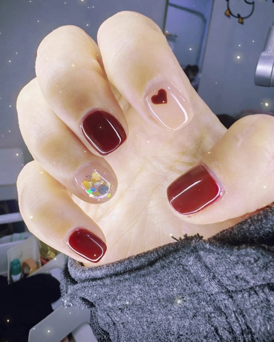 Primo piano di una pinzetta che posiziona pezzi di foglia oro su ununghia accent ricoperta di gel umido.
