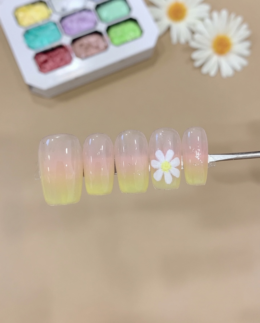 Una spugnetta che preme gel rosa e giallo sulla punta di ununghia, creando una morbida sfumatura ombré.