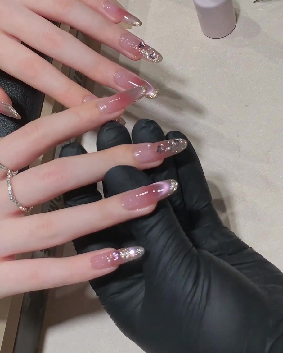 Un pennello applica un top coat lucido finale sopra un design con strass.