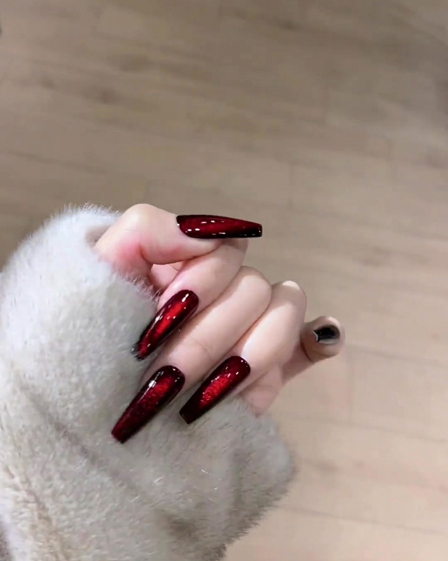 Una mano che utilizza un panno senza pelucchi per pulire la superficie di ununghia cat-eye.