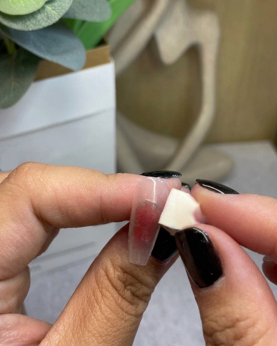 Primo piano di una spugnetta che sfuma il gel rosso verso lesterno per completare la transizione del gradiente.