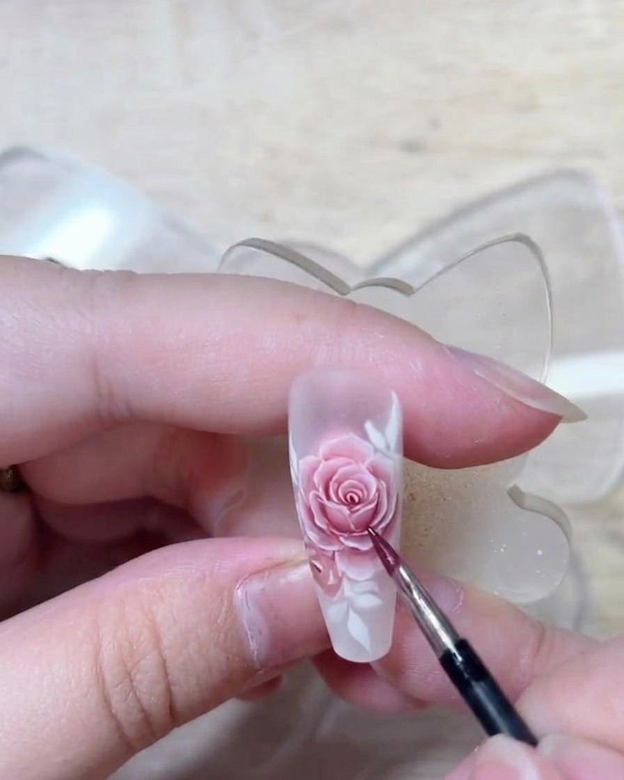 Un primo piano dellunghia che mostra tutti i corpi delle rose riempiti con un rosso chiaro, con transizioni e punti luce visibili.