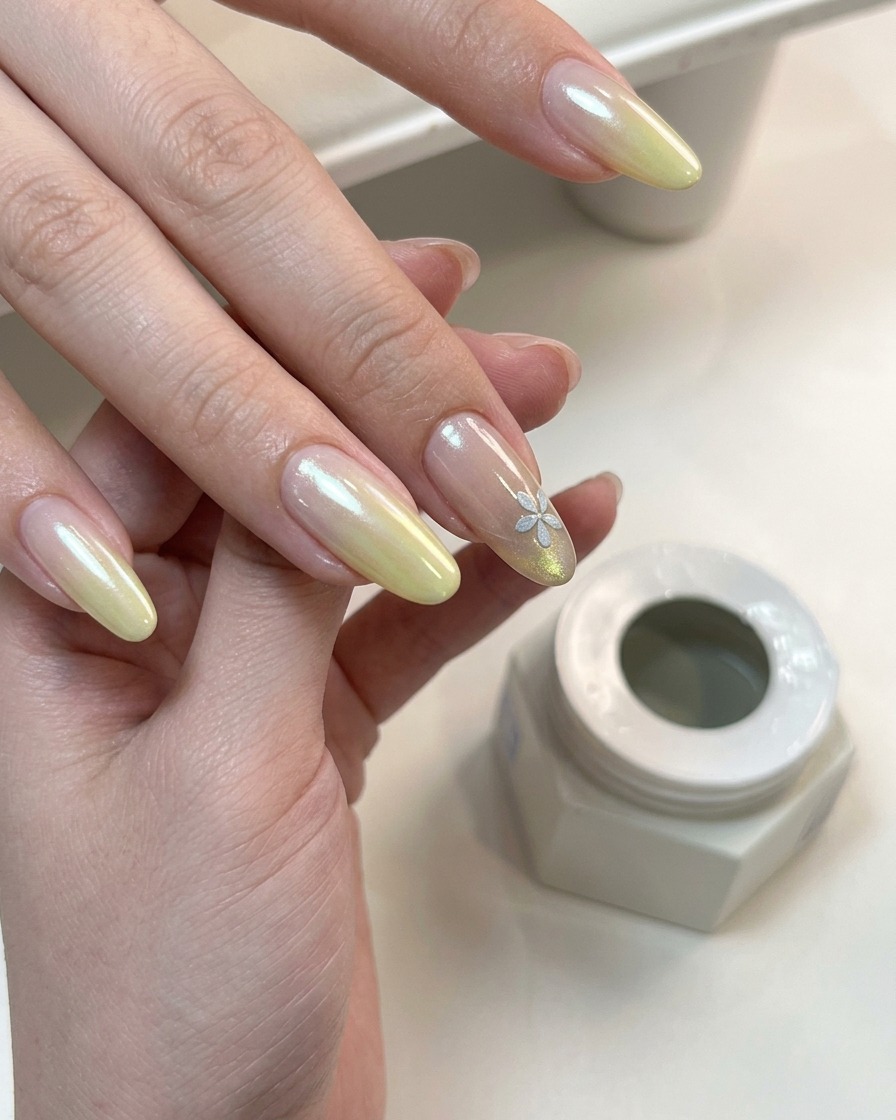 Una mano con nail art sfumata e floreale in polimerizzazione sotto una lampada UV.