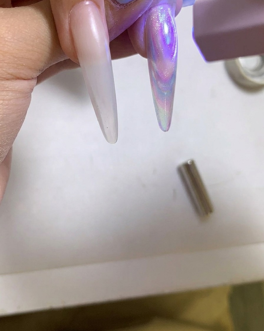 Una lampada UV/LED portatile che polimerizza unghie in gel cat eye lucide.