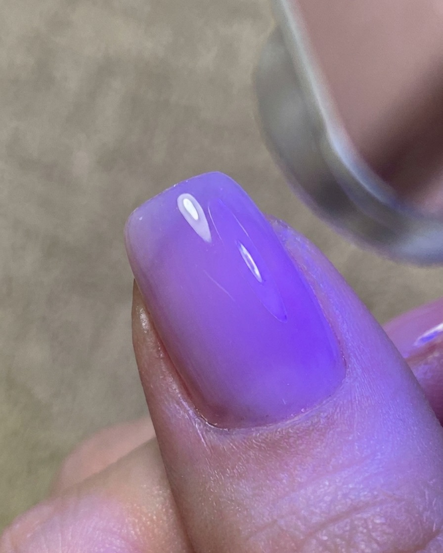 Un sottile strato di gel trasparente applicato sullunghia, creando una superficie lucida e appiccicosa.