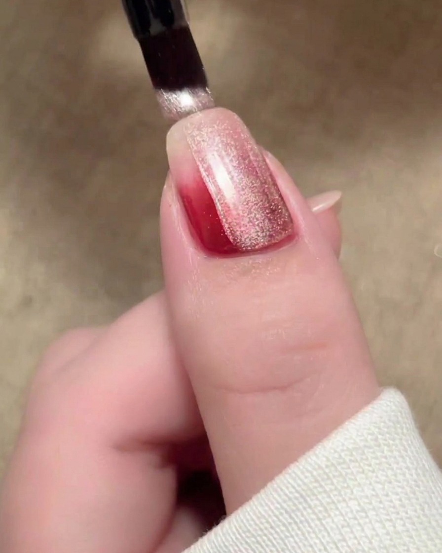 Una pennellata di smalto magnetico cat-eye beige che copre la superficie dellunghia.