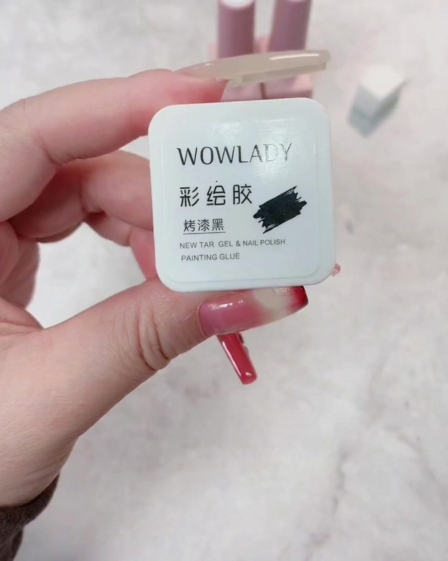 Un pennello che applica lo smalto gel rosso scuro su ununghia preparata, garantendo una copertura uniforme.