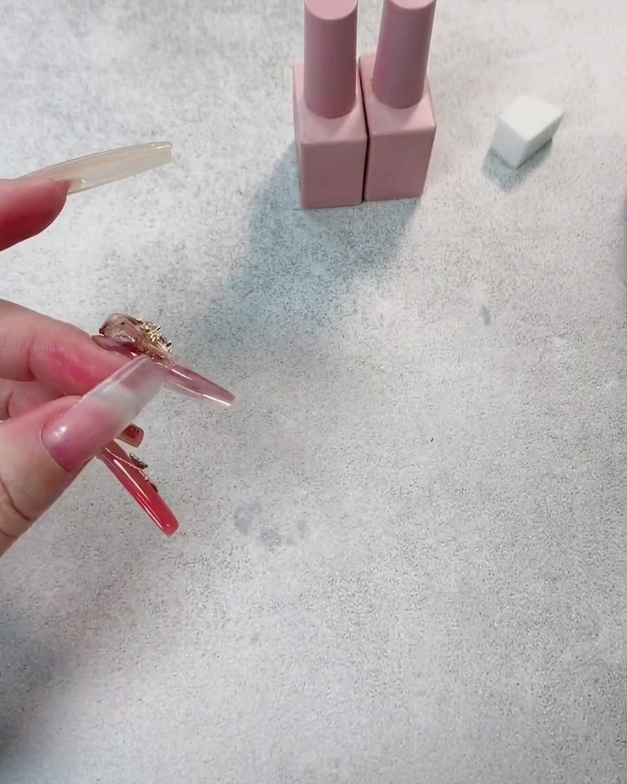 Un primo piano di ununghia che riceve una seconda mano di smalto gel rosso scuro, mostrando una maggiore profondità di colore.