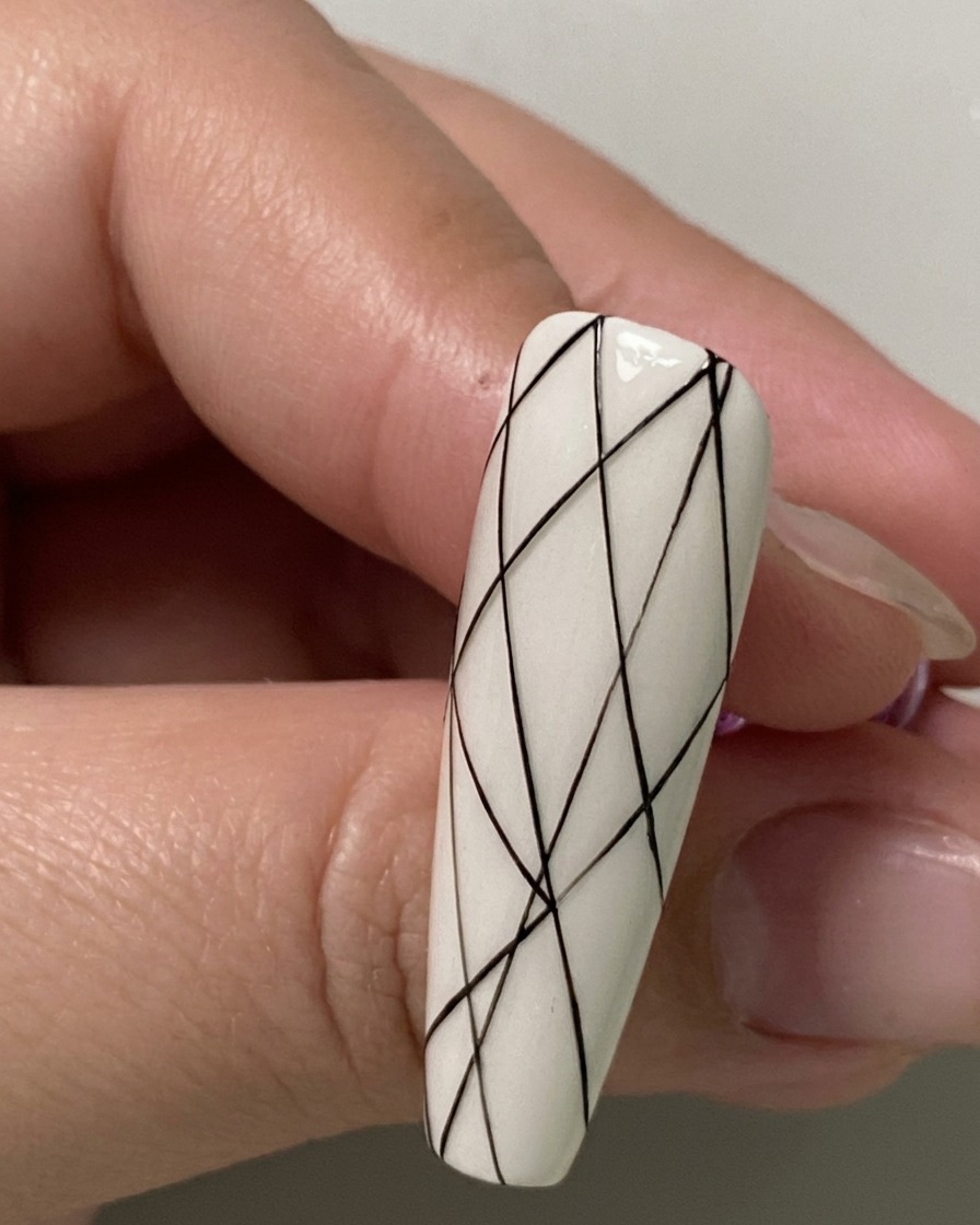 Primo piano di ununghia che mostra piccoli punti di spaziatura neri contrassegnati lungo la sezione inferiore.
