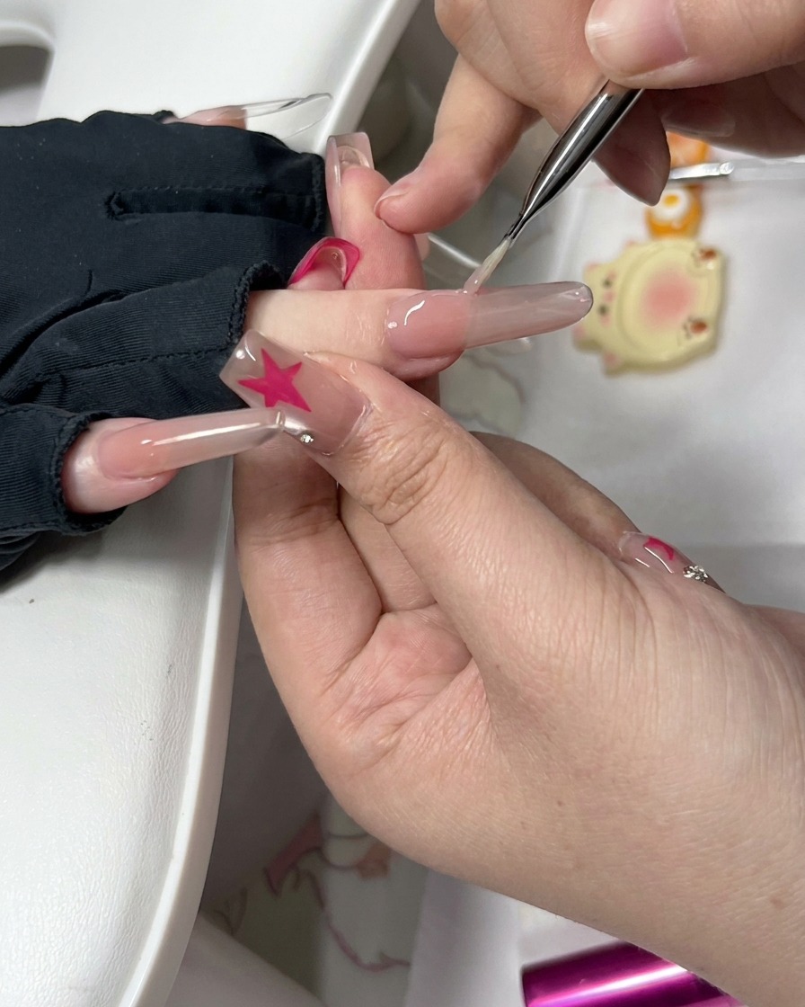 Primo piano di uno strumento di precisione e di una piccola spugnetta che puliscono i bordi di ununghia preparata.