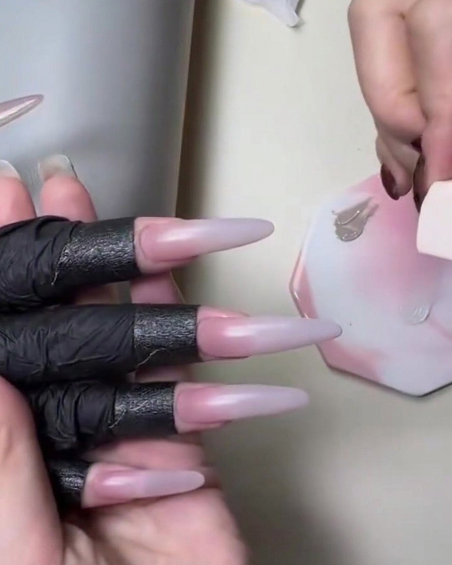 Una spugnetta applica un gel color carne vicino a una tavolozza bianca durante un tutorial per unghie sfumate.